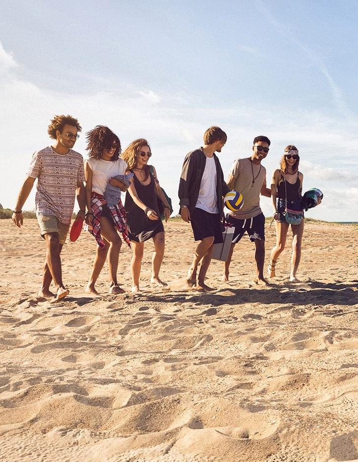 students walk on the s和 on the beach