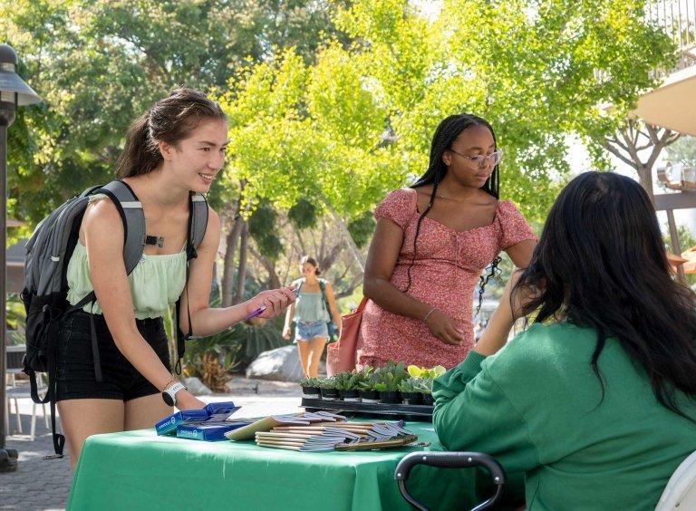 two student sign up at a strive 2 thrive table