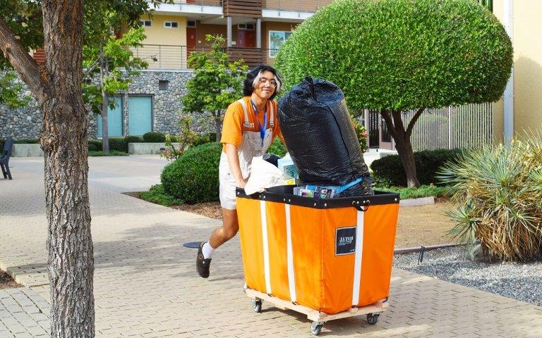 一名学生工作人员在搬家当天帮助将物品搬到宿舍